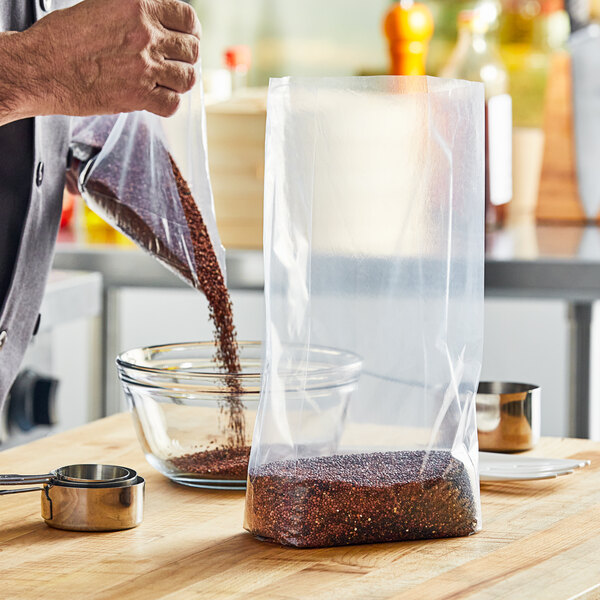 A person pouring brown grains into a Choice plastic food bag.
