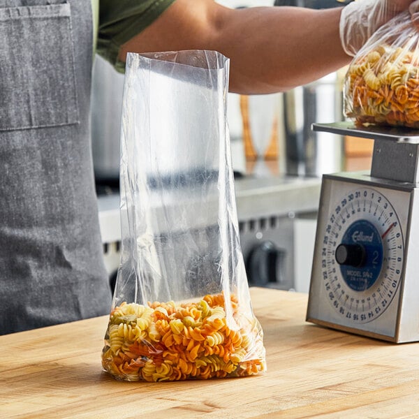A person weighing pasta in a Choice plastic bag.