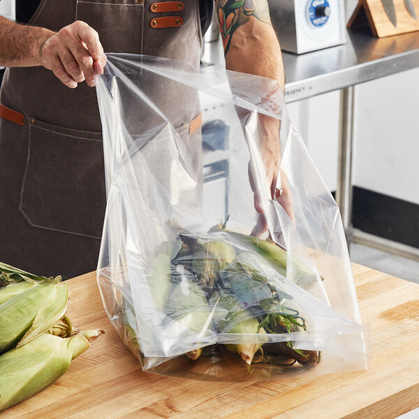 A person holding a Choice heavy-duty plastic bag of corn on the cob.