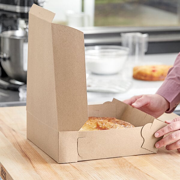 A person opening a Kraft pie box to reveal food inside.