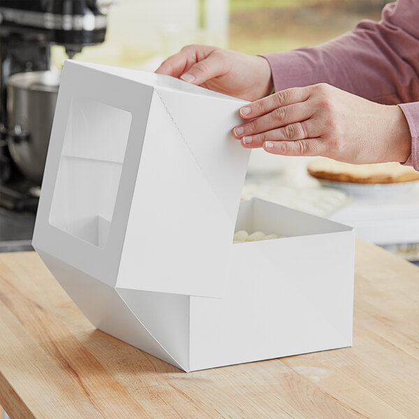 A person opening a white Auto-Popup Window Bakery Box with a lid