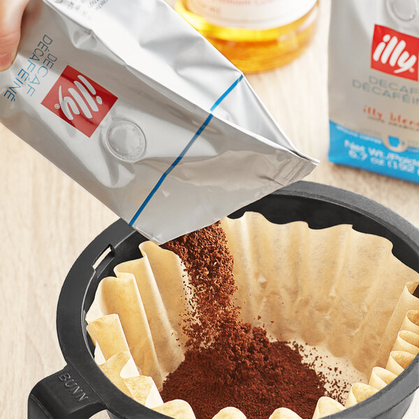 A person pouring illy Decaf Classico coffee into a filter.