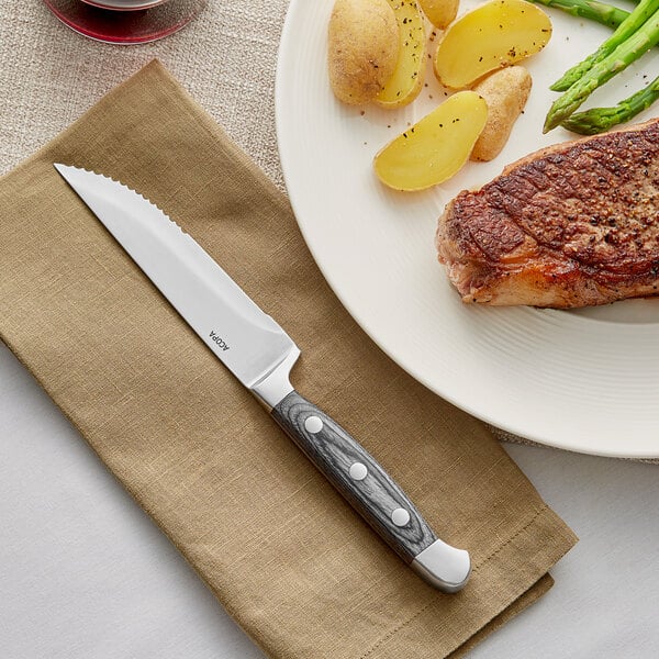 A piece of steak on a plate with a knife.