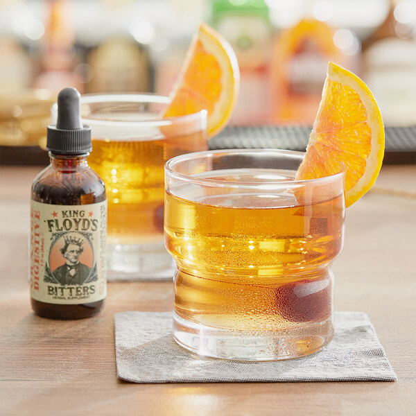 A glass of King Floyd's Orange Digestive Bitters with orange slices on top.