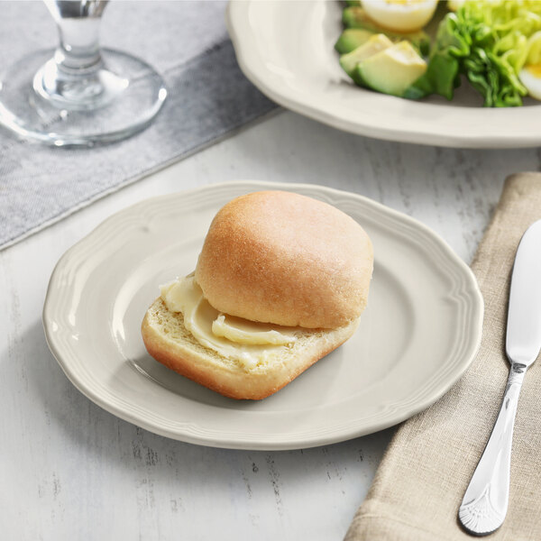 An Acopa Condesa warm gray porcelain plate with a sandwich and salad on it.