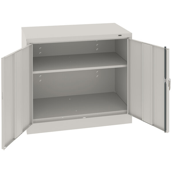 A light gray metal Tennsco storage cabinet with open doors.