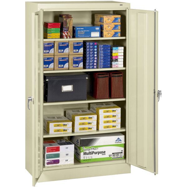 A Tennsco standard storage cabinet with many boxes on the shelves.