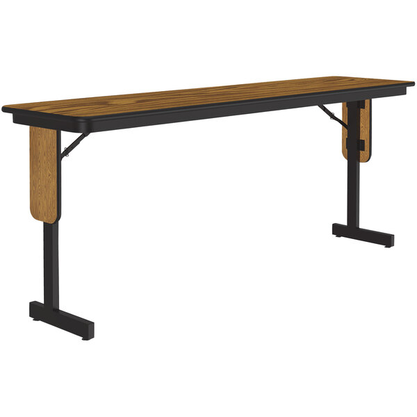 A Correll rectangular seminar table with medium oak thermal-fused laminate top and black panel legs.