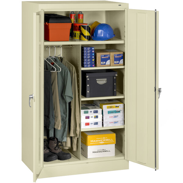 A metal Tennsco standard combination cabinet with solid doors filled with various items.