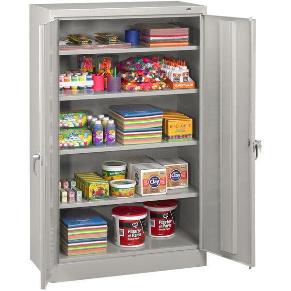 A light gray Tennsco storage cabinet with shelves full of items.