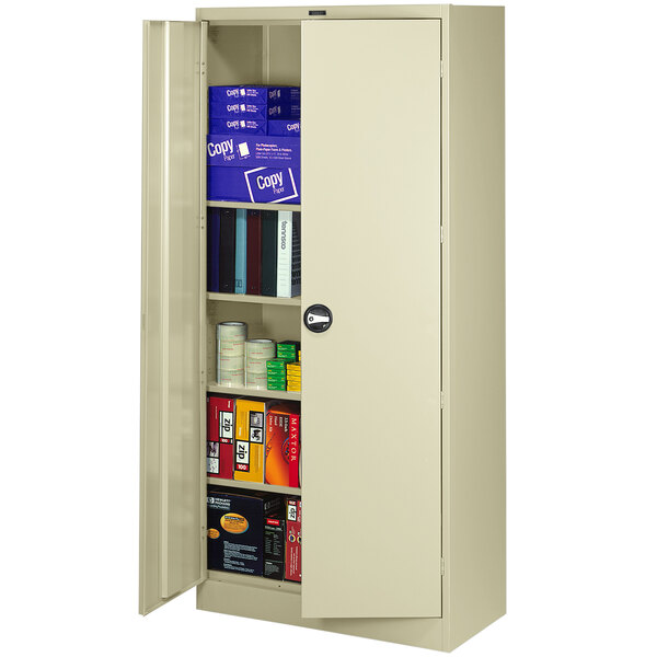 A metal Tennsco storage cabinet with shelves full of books and binders.