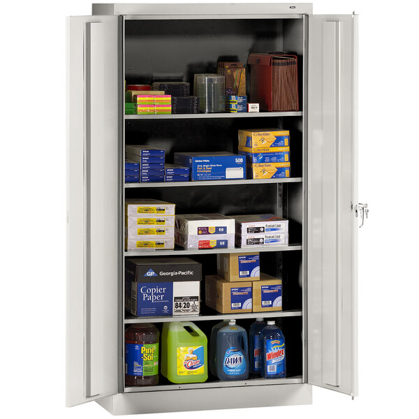 A light gray Tennsco storage cabinet with boxes and containers on shelves.