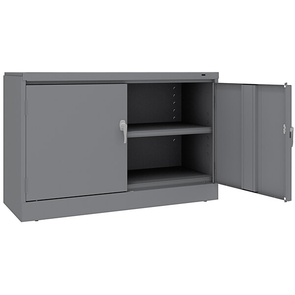 A dark gray metal Tennsco storage cabinet with open doors.