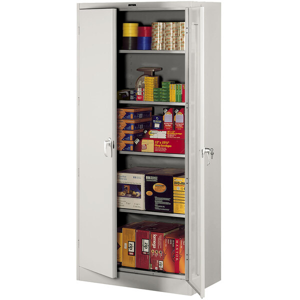 A light gray Tennsco metal storage cabinet with shelves full of items.