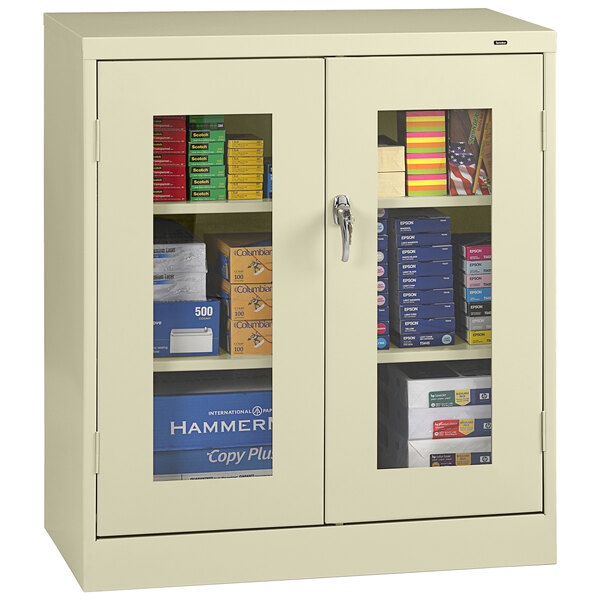 A Tennsco standard storage cabinet with a C-Thru door and a glass door with books and files inside.