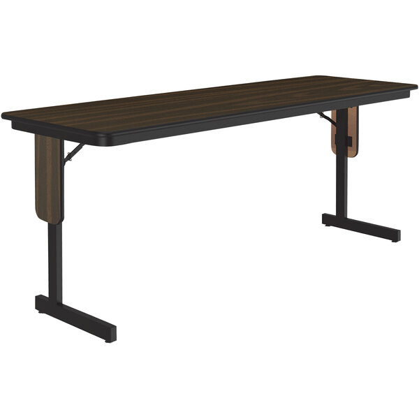 A Correll rectangular seminar table with a walnut top and black panel legs.