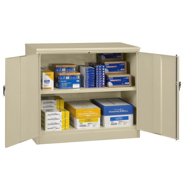 A sand Tennsco jumbo storage cabinet with solid doors and white text on a yellow box.