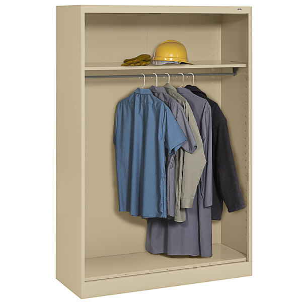 A sand Tennsco open-style wardrobe cabinet with clothes inside.
