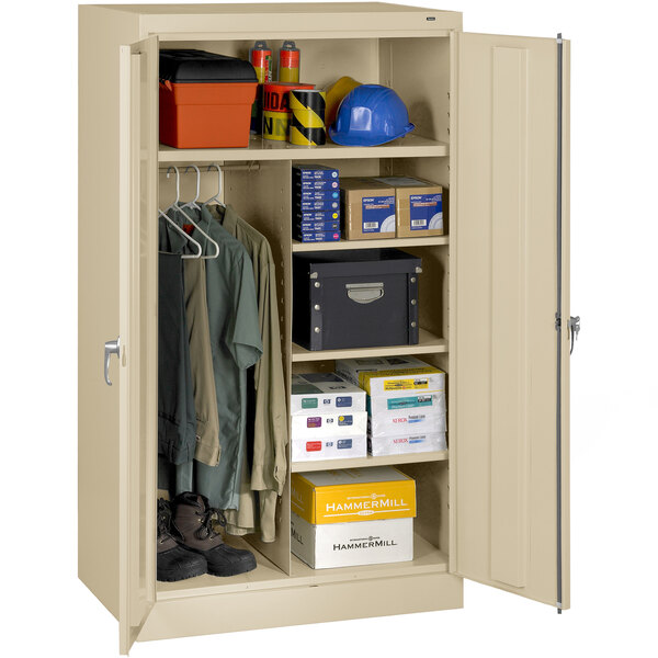 A tan Tennsco combination cabinet with solid doors filled with various items.