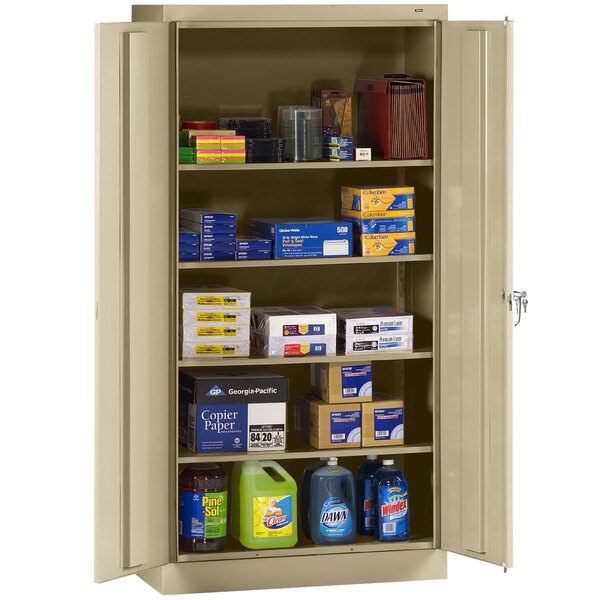 A Tennsco sand metal storage cabinet with solid doors filled with various items.
