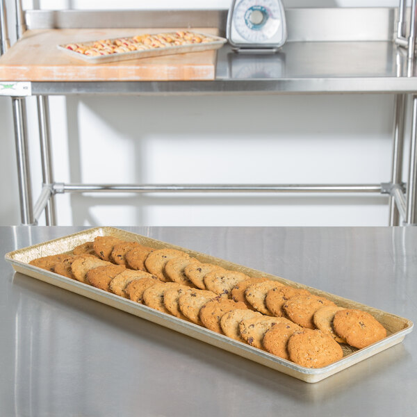 A MFG Tray Goldtex fiberglass bakery display tray with cookies on a table.