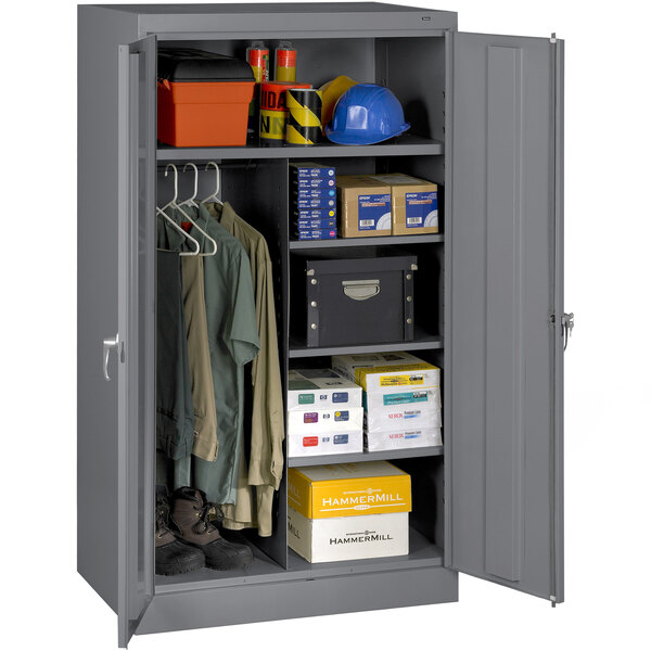 A dark gray Tennsco metal storage cabinet with solid doors filled with items.