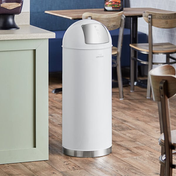 A Lancaster Table & Seating white steel waste receptacle with push door lid.