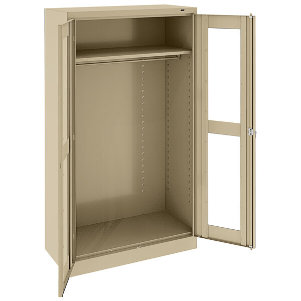 A tan metal Tennsco wardrobe cabinet with open C-thru doors.