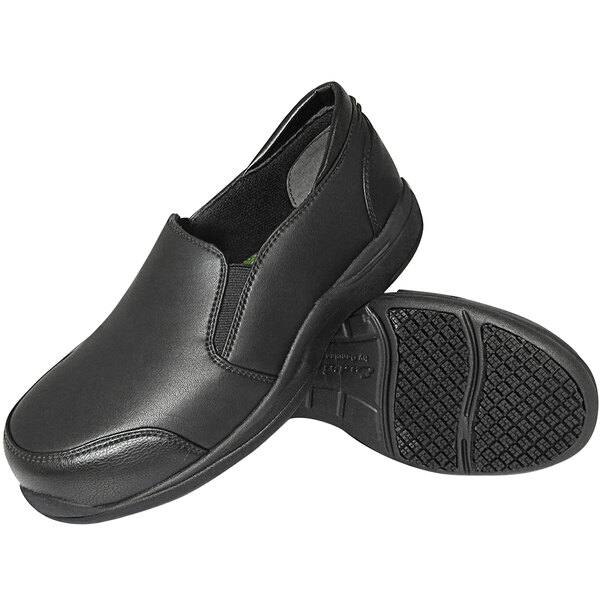 A pair of Genuine Grip black slip-on shoes with black soles.