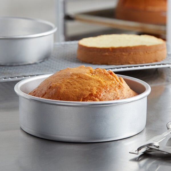 A Choice round aluminum cake pan with a cake in it.