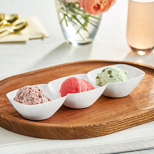 A white plastic mini tray with three bowls of ice cream on a table.