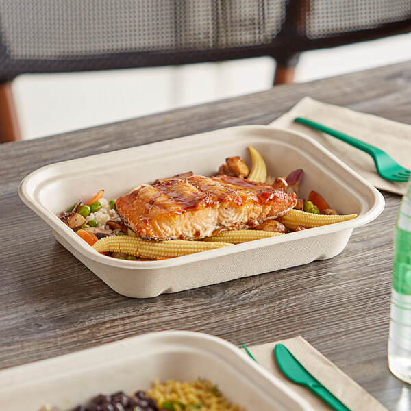 A World Centric compostable fiber box filled with food on a table.