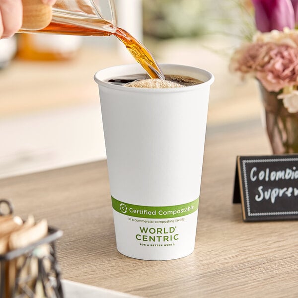 A person pouring coffee into a World Centric white paper hot cup.