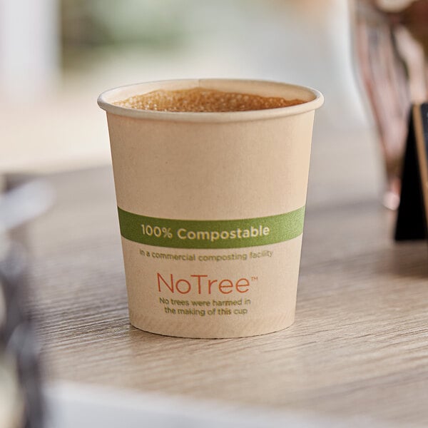 A World Centric compostable paper hot cup of coffee on a table.