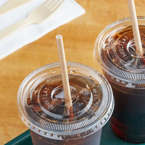 Two plastic cups with brown liquid and World Centric Kraft Giant Unwrapped Paper Straws in them.