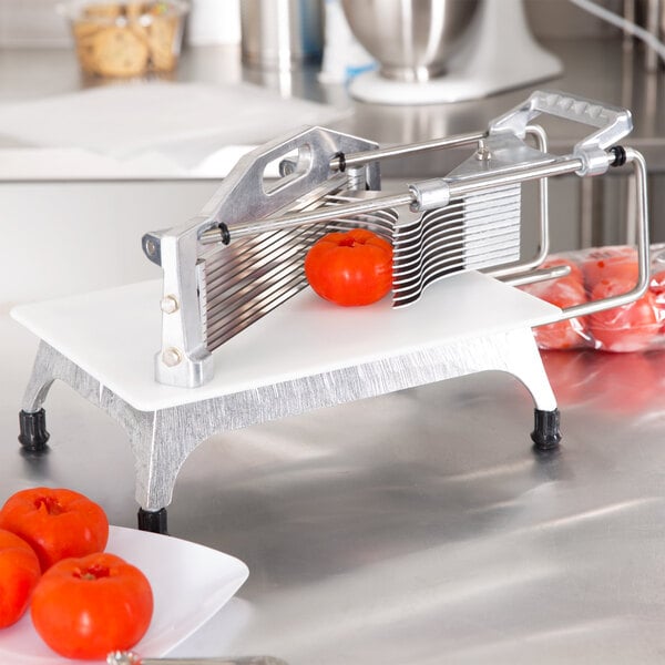 A Vollrath Redco tomato slicer with tomatoes on it.