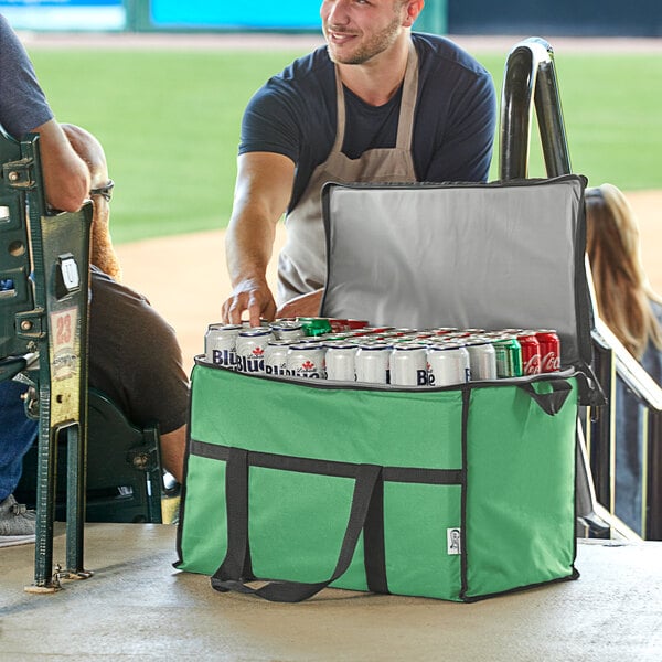A man in an apron opening a green Choice insulated cooler bag full of cans of beer.