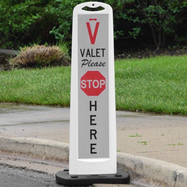 A white vertical valet panel with a red and white "Please Stop Here" sign on it.