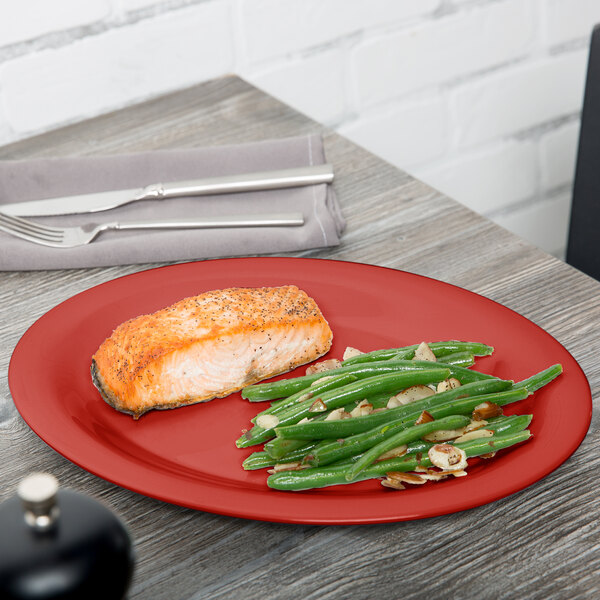 A Cranberry Diamond Harvest oval platter with a piece of salmon and green beans on it.