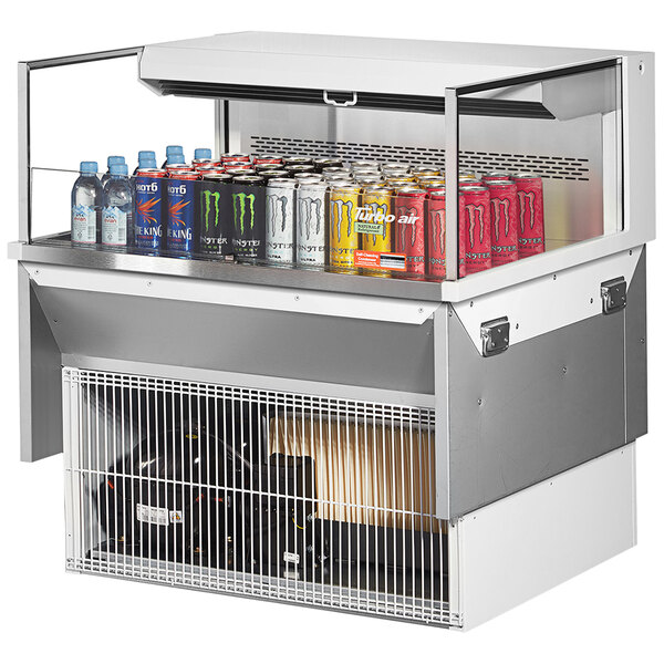 A Turbo Air drop-in refrigerated display case with cans of soda and energy drinks.