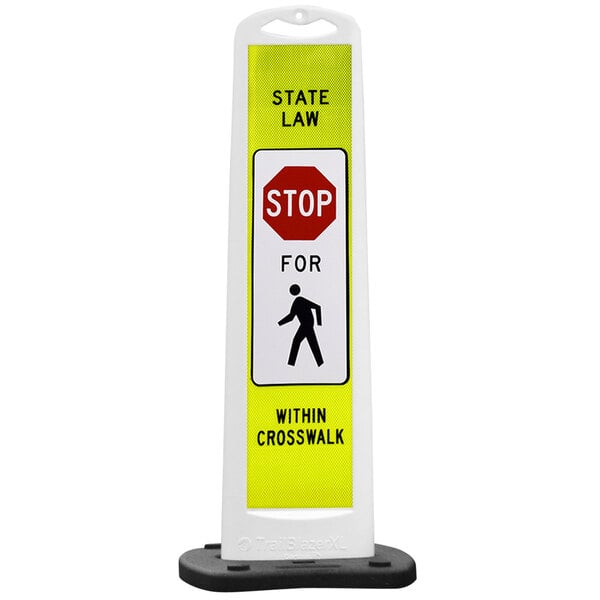A white vertical panel with a yellow and black sign that says "State Law Stop For Pedestrian Crossing" on it.