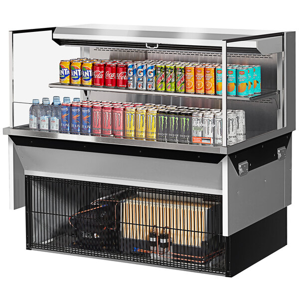 A Turbo Air drop-in refrigerated display case with cans of soda on a shelf.
