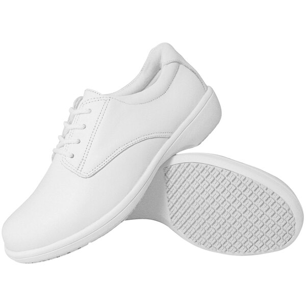 A pair of Genuine Grip white non-slip slip-on shoes.