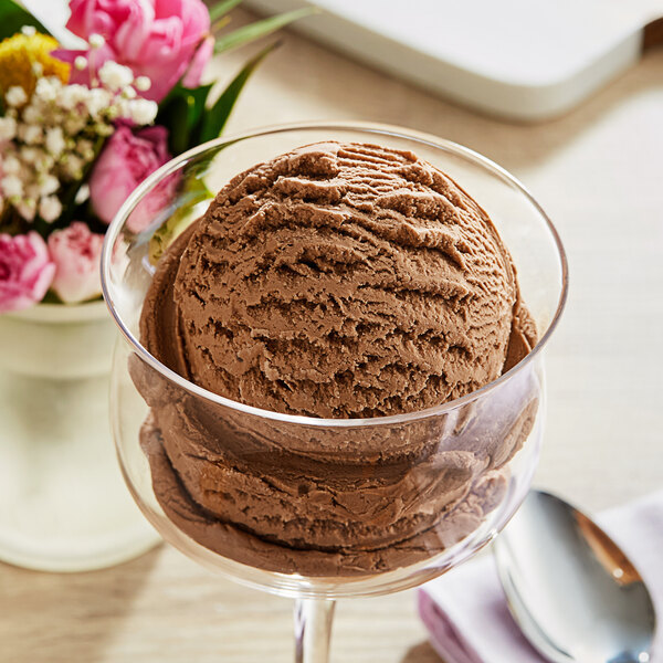 A scoop of Oringer maple hard serve ice cream with chocolate flavoring in a glass.
