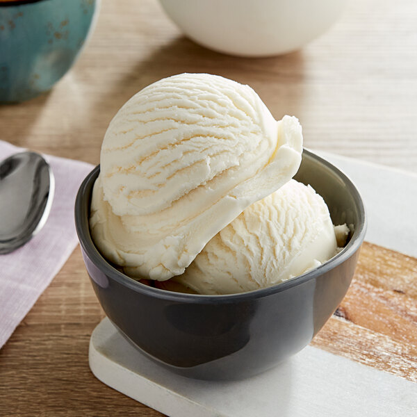 A bowl of Oringer Jamaican Rum flavored ice cream on a white surface with a brown edge.