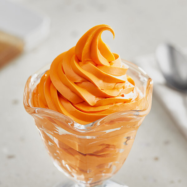 A glass bowl of swirled orange ice cream with Oringer Orange Dream flavoring on top.