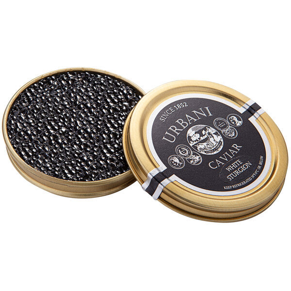 A round tin of Urbani White Sturgeon Caviar on a table with a gold lid filled with black caviar.