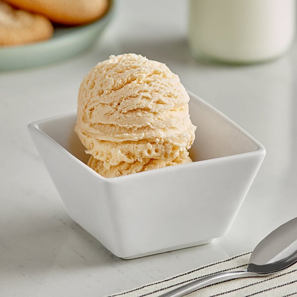 A bowl of Oringer peach ice cream with a spoon.