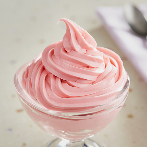 A glass bowl of pink Oringer Watermelon Dream soft serve ice cream.