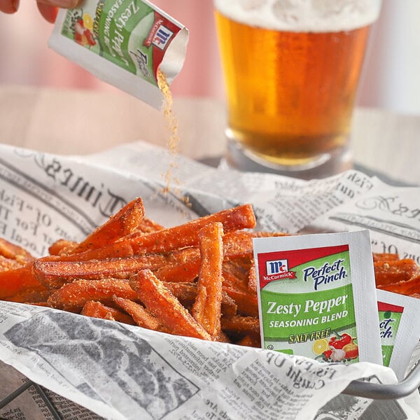 A bowl of fries with a packet of McCormick Perfect Pinch Zesty Pepper Seasoning.